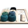 Zestaw do nauki tkania w zielonych odcieniach - przędza, osnowa, patyki i duża ramka do tkania.