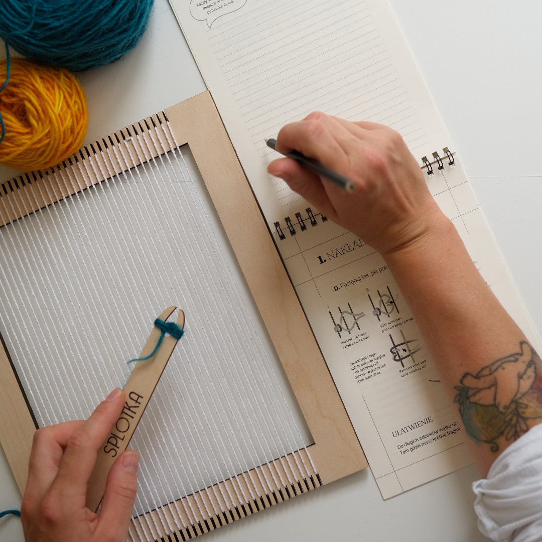 książeczka do tkania leżąca przy ramce tkackiej – narzędzia DIY